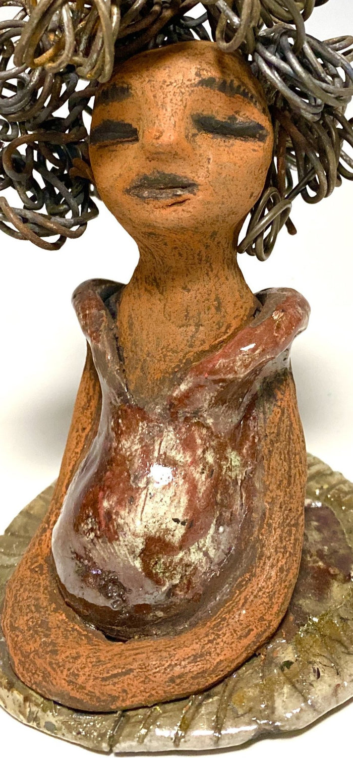 Meet Carleen! Carleen  stands 6" x 4" x 4" and weighs 12 ozs. Carleen has a honey brown complexion with 16 gauge curled wire hair. She wears an copper metallic dress. Carleen  has her long loving arms at her side as she rest and waits.