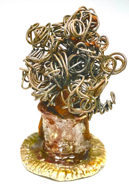 Meet Carleen! Carleen  stands 6" x 4" x 4" and weighs 12 ozs. Carleen has a honey brown complexion with 16 gauge curled wire hair. She wears an copper metallic dress. Carleen  has her long loving arms at her side as she rest and waits.