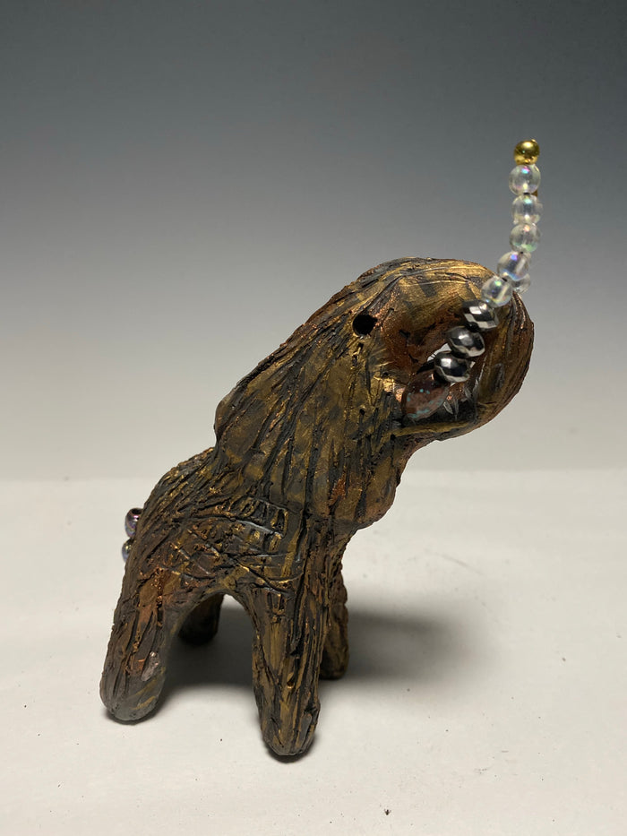 Have you HERD!!!!!!   Elephants are one of my favorite animals to create. They are so majestic"  Just one of these lovely Raku Fired Elephant will make an excellent gift for your  BFF,  or just for you .    This raku fired baby elephant sits 6" x 4" x 4" and weighs 10 ounces. She has beaded tusks and a textured copper body.  This little baby is Nice!
