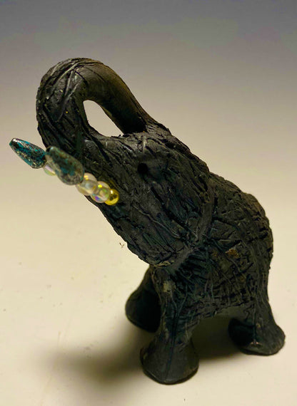 Elephants are one of my favorite animals to create. They are so majestic"  Just one of these lovely Raku Fired Elephant will make an excellent gift for your  BFF,  or just for you .    This raku fired elephant stands 7" x 2" x 2.5" and weighs  7 ounces. She has beaded tusks and a textured charcoal  body. Nice!