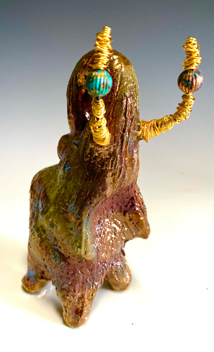 Raku Elephant Have you HERD!!!!!!  Just one of these lovely Raku Fired Elephant will make an excellent gift for your  friend, sorority or for your home’ special place centerpiece.  6" x 4" x 5" 14 ozs. Beautiful copper, green and gold metallic raku elephant  Gold beaded tusk  For decorative purposely only.