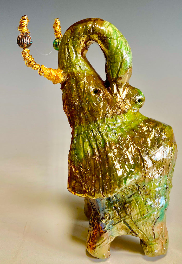 Raku Elephant Have you HERD!!!!!!  Just one of these lovely Raku Fired Elephant will make an excellent gift for your  friend, sorority or for your home’ special place centerpiece.  6" x 4" x 5" 14 ozs. Beautiful copper, green and gold metallic raku elephant  Gold beaded tusk  For decorative purposely only.