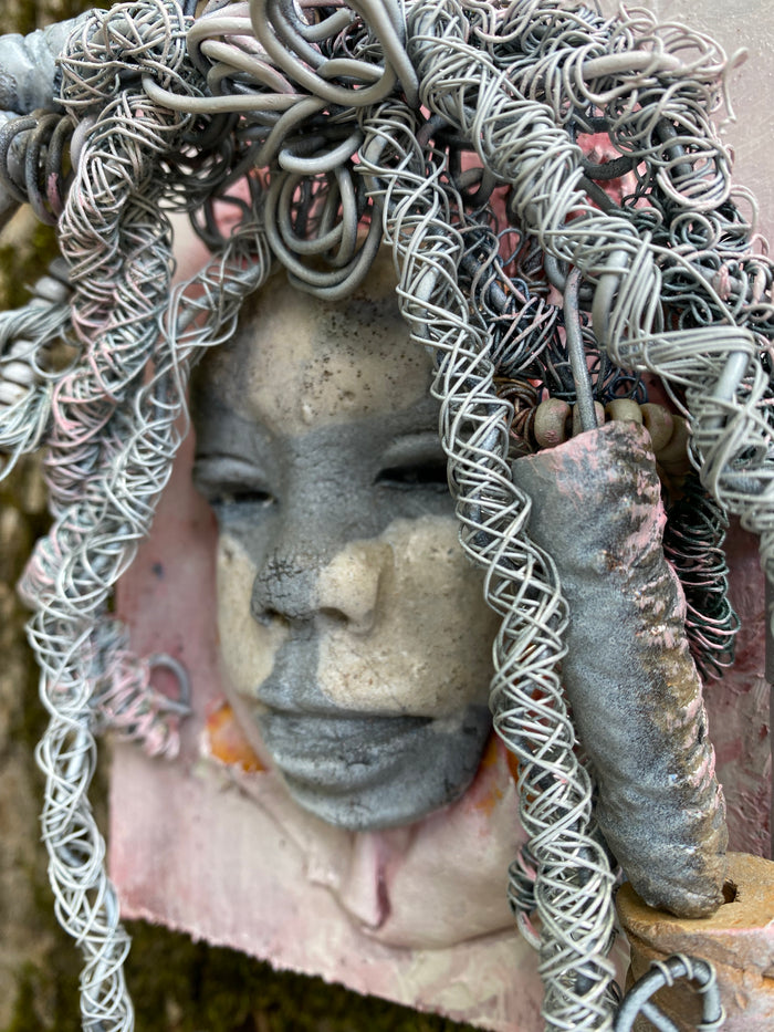 Bring a bit of quirk to your walls with Venice! This one-of-a-kind folk art piece is mounted on a painted 5”x 6” wood canvas and features over 40 feet of wired hair and Raku beads! With white , antique crackle face and lips, she is sure to liven up any space. Whether you want a conversation starter or just an eye-catching piece of art, Venice is ready to be hung! Got questions? Just ask!Got Questions??