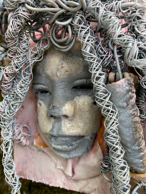 Bring a bit of quirk to your walls with Venice! This one-of-a-kind folk art piece is mounted on a painted 5”x 6” wood canvas and features over 40 feet of wired hair and Raku beads! With white , antique crackle face and lips, she is sure to liven up any space. Whether you want a conversation starter or just an eye-catching piece of art, Venice is ready to be hung! Got questions? Just ask!Got Questions??