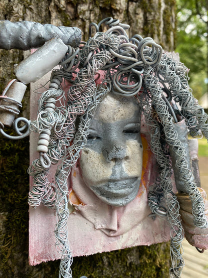 Bring a bit of quirk to your walls with Venice! This one-of-a-kind folk art piece is mounted on a painted 5”x 6” wood canvas and features over 40 feet of wired hair and Raku beads! With white , antique crackle face and lips, she is sure to liven up any space. Whether you want a conversation starter or just an eye-catching piece of art, Venice is ready to be hung! Got questions? Just ask!Got Questions??