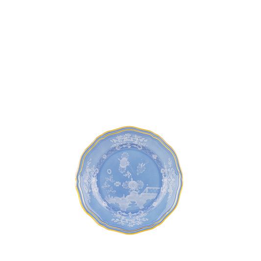 Blue ceramic bread and butter plate with white floral design and gold trim.
