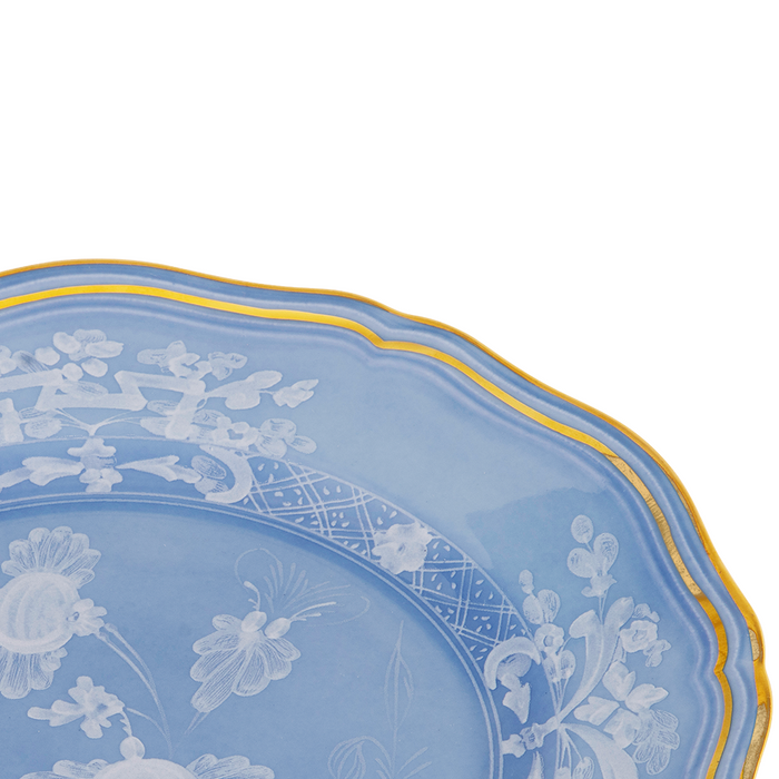 Blue ceramic bread and butter plate with scalloped edges, white floral pattern, and gold trim.