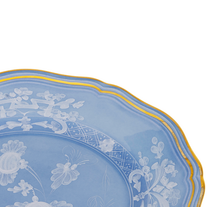 Blue ceramic bread and butter plate with scalloped edges, white floral pattern, and gold trim.