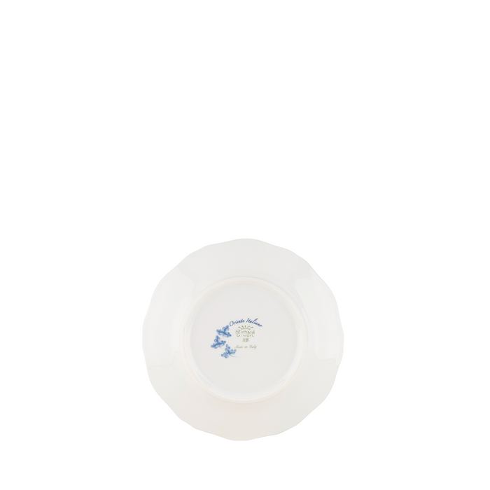 White ceramic bread and butter plate with scalloped edges and delicate blue floral design at center.