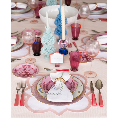 Porpora bread and butter plate with pink floral design, gold rim, and matching flatware on pink tablecloth.