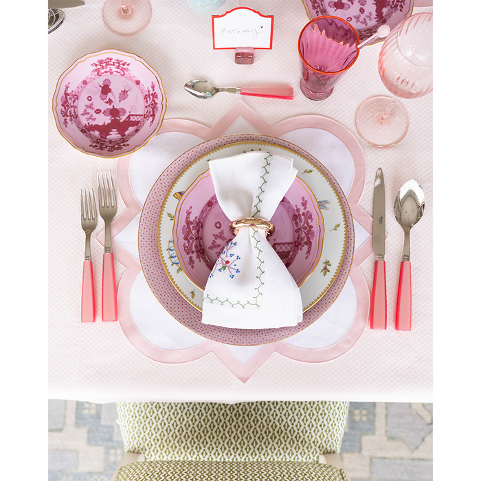 Round Porpora bread and butter plate with pink floral pattern and gold rim on elegant table setting.