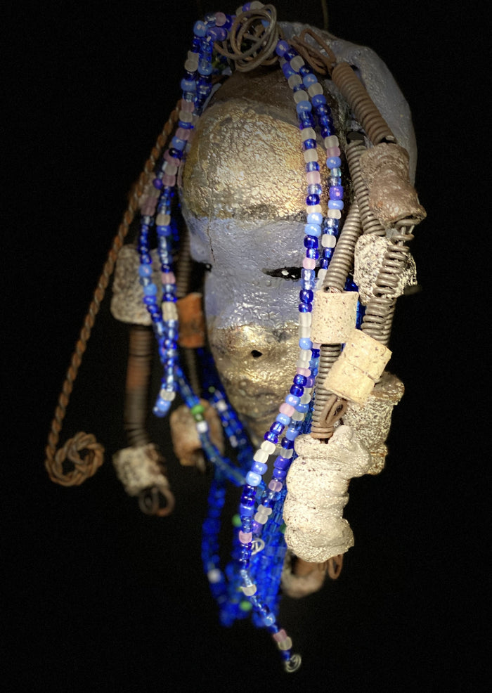 Meet Randi! I started making art soon after seeing authentic African artwork at the Smithsonian Museum of African Art. I was in total awe. Randi was inspired by my visit there.   Randi has a two tone complexion of golden silver and blue. She is 8" x 6" and weighs 14 ozs. Randi has over 10 raku beads. She has over 200 of multi shade of blue and white mini beads. Randi has over 10 feet of  coiled copper and 16 gauge wire hair.