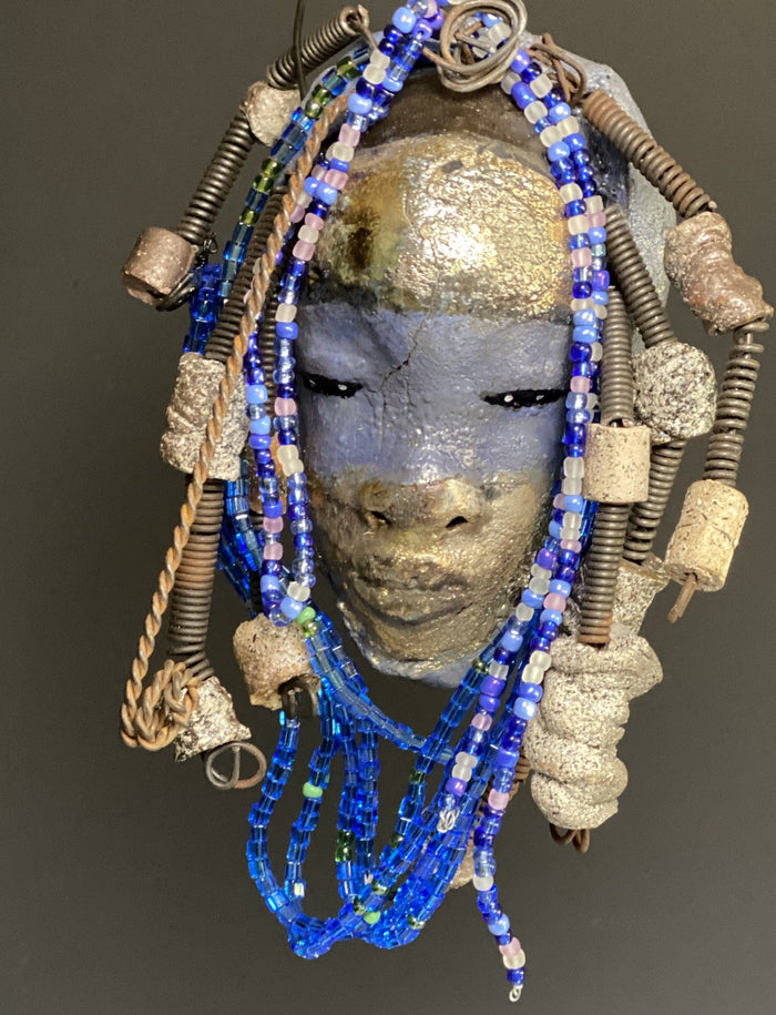 Meet Randi! I started making art soon after seeing authentic African artwork at the Smithsonian Museum of African Art. I was in total awe. Randi was inspired by my visit there.   Randi has a two tone complexion of golden silver and blue. She is 8" x 6" and weighs 14 ozs. Randi has over 10 raku beads. She has over 200 of multi shade of blue and white mini beads. Randi has over 10 feet of  coiled copper and 16 gauge wire hair.