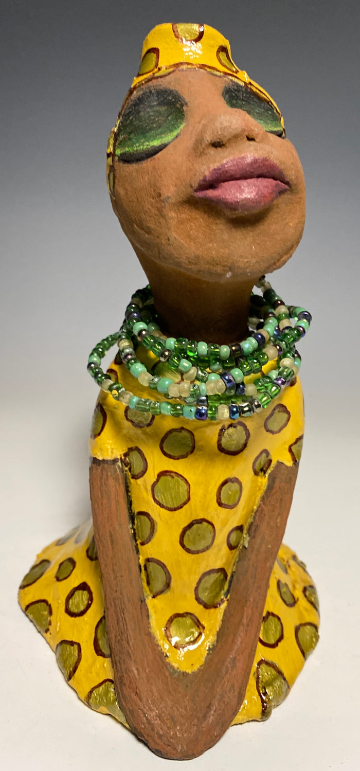 Meet Sharon! Sharon stands" 8 x 5" x 5" and weighs 1.5 lbs She wears a cute spotted autumn yellow dress with matching hat and emerald green beads. Her long loving arms rest at her side. Check out Sharon's little sister named Shelia! With the current situation we All are going through, Shelia will place a smile on your face during this challenging time.