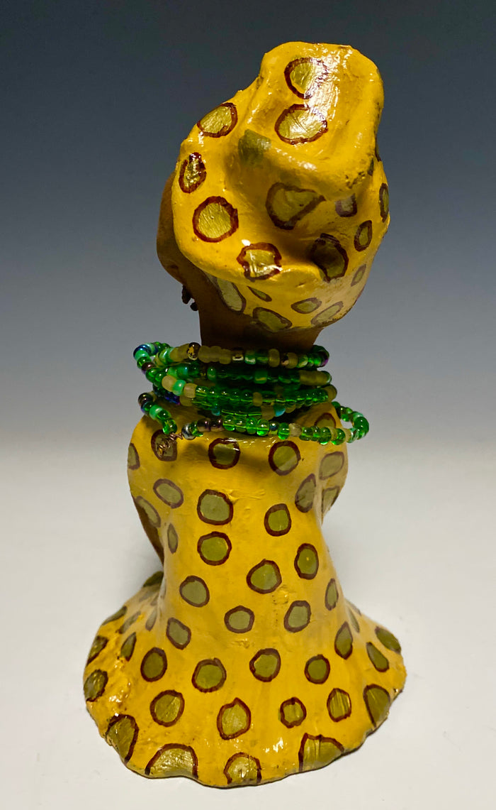 Meet Sharon! Sharon stands" 8 x 5" x 5" and weighs 1.5 lbs She wears a cute spotted autumn yellow dress with matching hat and emerald green beads. Her long loving arms rest at her side. Check out Sharon's little sister named Shelia! With the current situation we All are going through, Shelia will place a smile on your face during this challenging time.
