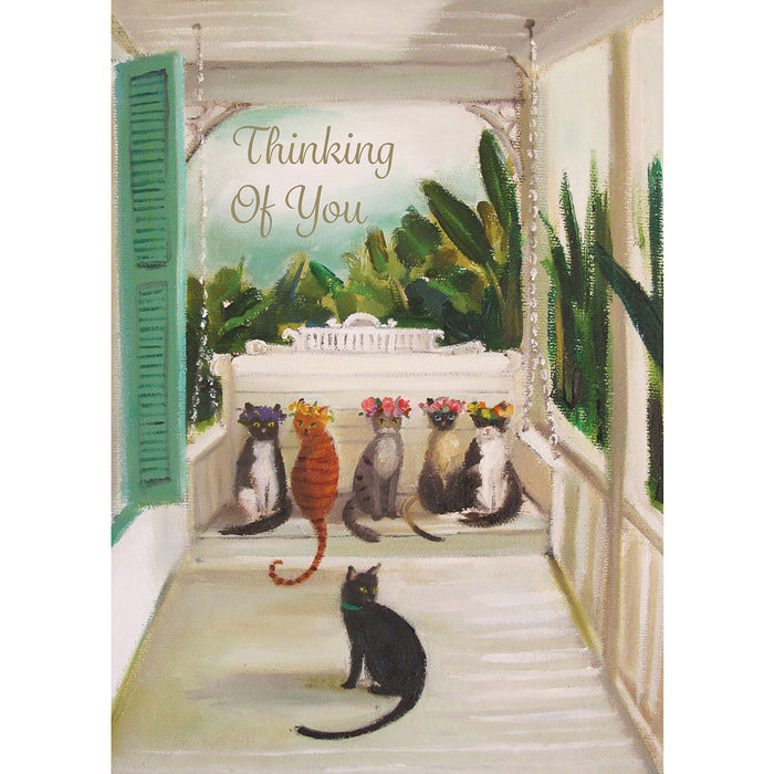 A painterly illustration of a luxurious front porch with a white porch swing bench; sitting on the bench is a group of five variously colored cats in flower crowns, and on the porch below them is a single black cat with a green collar. The message "Thinking Of You" is printed in gold script above the scene.