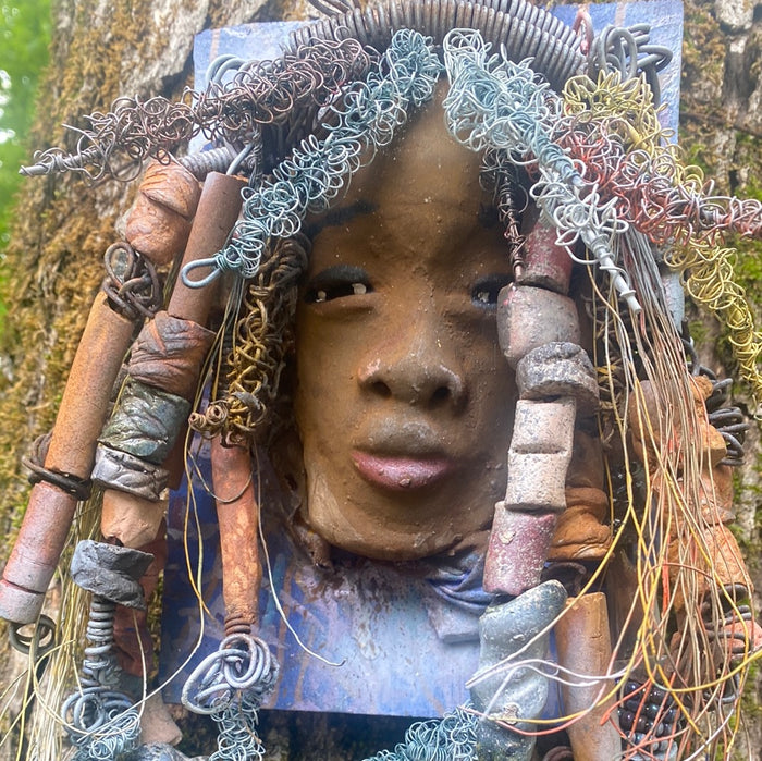 Valarie is mounted  5” x 8 x 1 and weighs 1.13 lbs.   She has a contagious smile. Valarie face has a lovely honey brown complexion. She has over 20 handmade raku fired beads  Over 60 feet of 16 and 24 gauge twisted wire for hair!