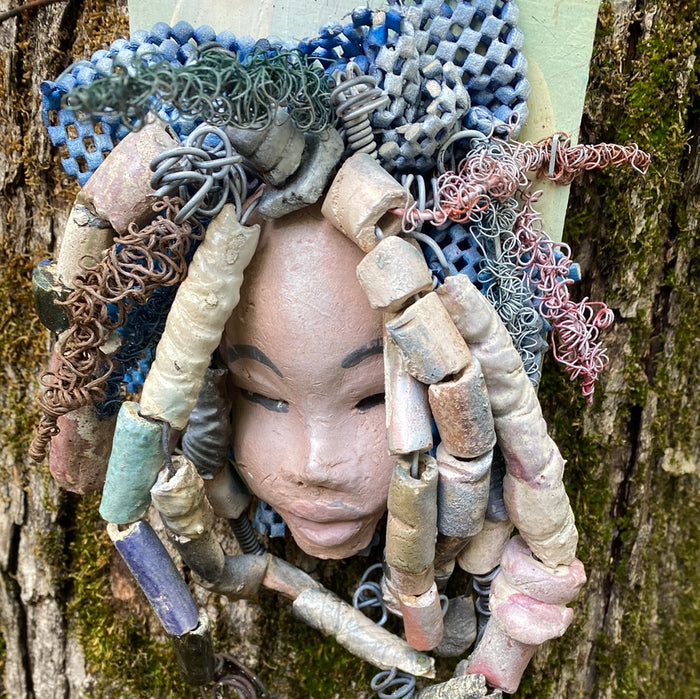 Zaire is mounted on a  5"x 6" painted wood canvas. I spent about 4 hours or more just  fixing her hair and attaching beads!  Zaire has over 100 feet of 16 and 24 gauge wire for hair. Zaire has a white crackle face with dark gray lips. She weighs 2.10 lbs  and is ready to be hung!