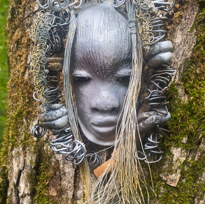 Zaya has a metallic  white complexion. She is 7" x 8" and weighs  11 ozs. Zaya has over 15 handmade raku fired beads. Zaya has over 25 feet of  copper coiled 16 gauge wire hair