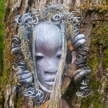 Zaya has a metallic  white complexion. She is 7" x 8" and weighs  11 ozs. Zaya has over 15 handmade raku fired beads. Zaya has over 25 feet of  copper coiled 16 gauge wire hair