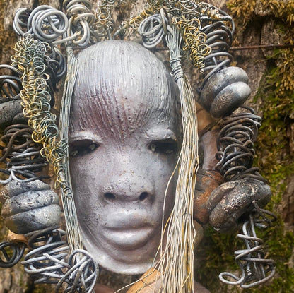 Zaya has a metallic  white complexion. She is 7" x 8" and weighs  11 ozs. Zaya has over 15 handmade raku fired beads. Zaya has over 25 feet of  copper coiled 16 gauge wire hair